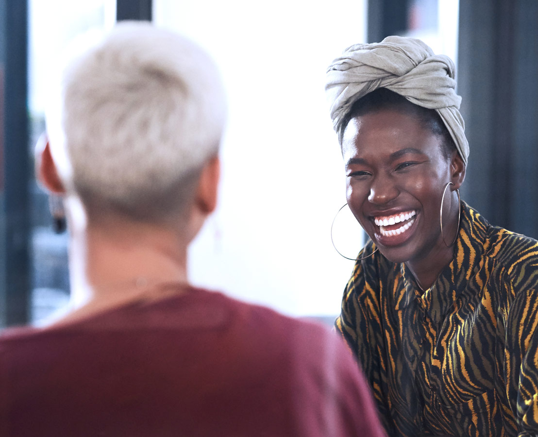 Netzwerke mit Partnern aufbauen. Bild von zwei Frauen, die sich lachend unterhalten.