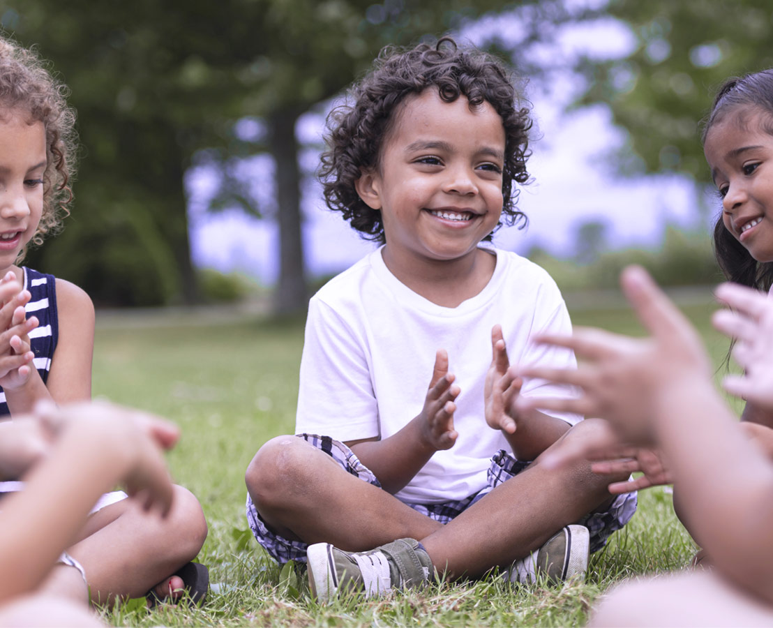 Gemeinschaften unterstützen. Bild von Kindern, die fröhlich im Kreis sitzen.