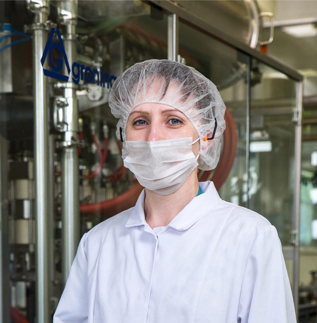 Bild einer Produktionsmitarbeiterin in Schutzkleidung. Unser Anliegen. 