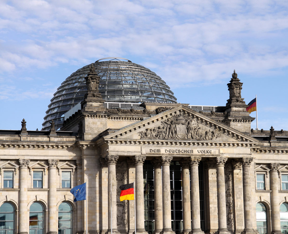 Bild des Reichstagsgebäudes in Berlin bei blauem Himmel.