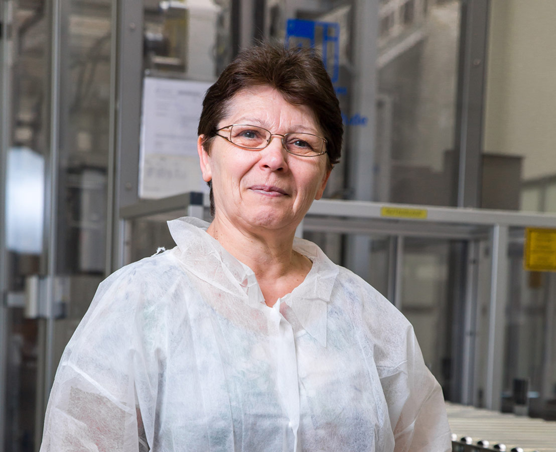 Bild einer Verpackungs-Mitarbeiterin mit Schutzanzug.