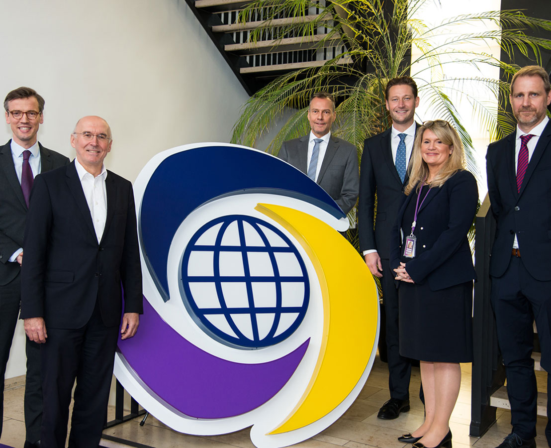 Viatris-Kollegen stehen neben Logo der Viatris-Gruppe.