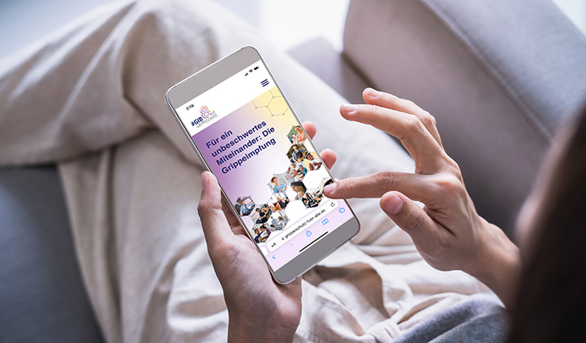 Bild einer Frau, die die Website www.grippeschutz-fuer-alle.de auf ihrem Mobilfunkgerät anschaut